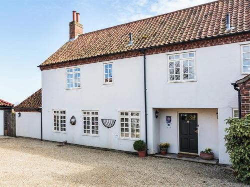 una casa blanca con una entrada delante de ella en Meadow View, en Wighton