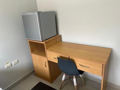 a wooden desk with a chair and a computer monitor on it at Hotel Reycer in Piura