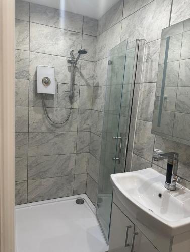 a bathroom with a shower and a sink at Studio T in Dagenham