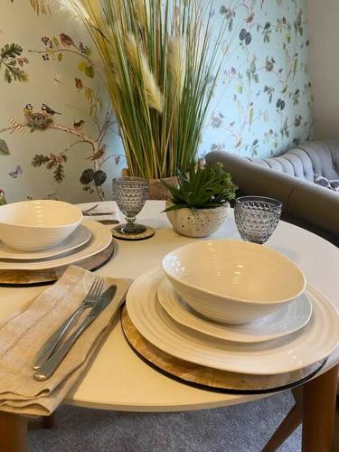 a table with plates and bowls on top of it at Serendipity ~ Romantic Hideaway in Ambleside in Ambleside