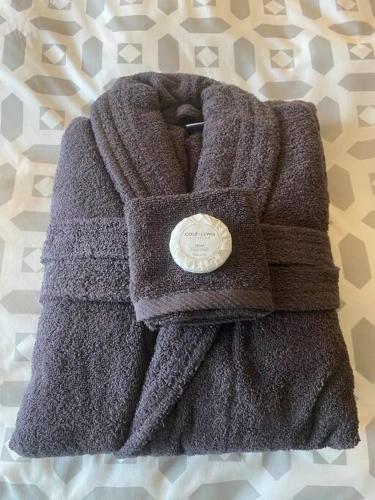 a purple sweater is sitting on a bed at Serendipity ~ Romantic Hideaway in Ambleside in Ambleside