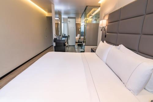 Un dormitorio con una gran cama blanca en una habitación. en GHL Collection 93, en Bogotá