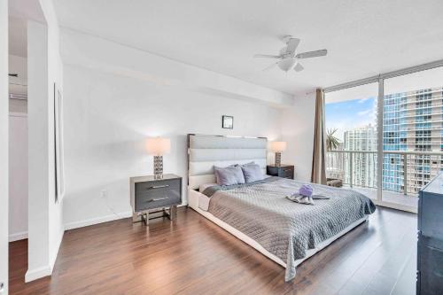 a white bedroom with a bed and a television at Modern 1 Bed in the Heart of Brickell With Free Parking in Miami