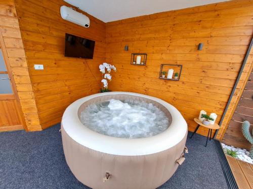 a bath tub in a room with a wooden wall at "Oasis of Peace Zagreb-Apartments" in Zagreb