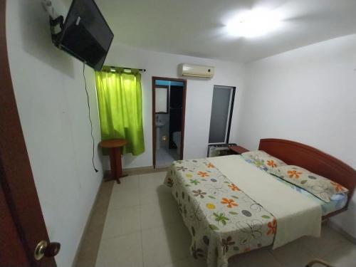a bedroom with a bed and a flat screen tv at Hotel Vip Comfort Santa Marta in Santa Marta