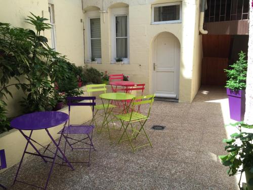 a group of colorful chairs and tables on a patio at Hôtel Le Chambellan in Dijon