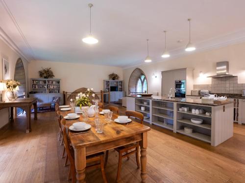 a kitchen and dining room with a wooden table at Greystead Old Church in Hexham