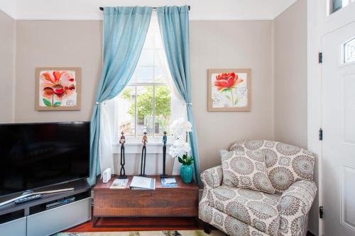 a living room with a chair and a television at Shotgun Craftman House with Private Patio in New Orleans