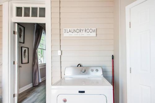a laundry room with a washer and dryer next to a door at Shotgun Craftman House with Private Patio in New Orleans