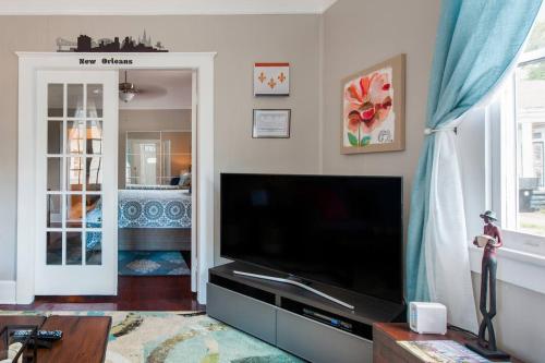 a living room with a large television and a living room at Shotgun Craftman House with Private Patio in New Orleans