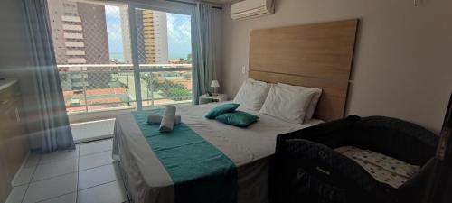 1 dormitorio con 1 cama y ventana grande en Sea Mar Flat, en Natal