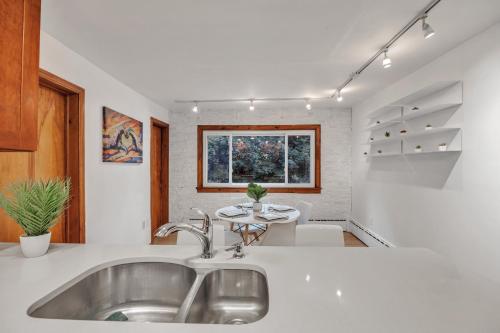 a kitchen with a sink and a table at Brand New Stylish Noho Apartment in Northampton