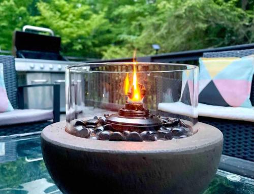a candle in a glass bowl on top of a table at Zen Spa Oasis Retreat Sauna/Hotub/Firepit/Fun/Gameroom in Blakeslee
