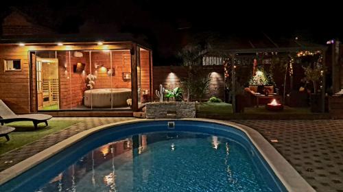 a swimming pool in front of a house at night at "Oasis of Peace Zagreb-Apartments" in Zagreb