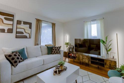 a living room with a white couch and a flat screen tv at Beautiful - 4bd with Contemporary Interior in Lincoln