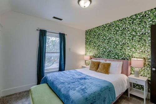 a bedroom with a bed and a green wall at Beautiful - 4bd with Contemporary Interior in Lincoln