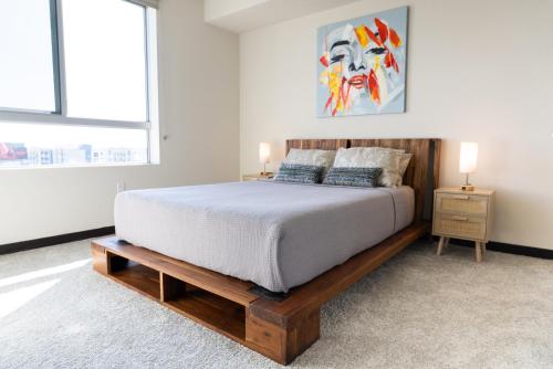 a bedroom with a large bed with a wooden frame at Luxury Apartment West Hollywood in Los Angeles