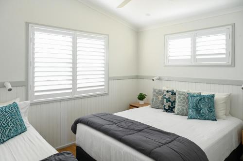 a bedroom with two beds and two windows at NRMA Toowoon Bay Holiday Park in The Entrance