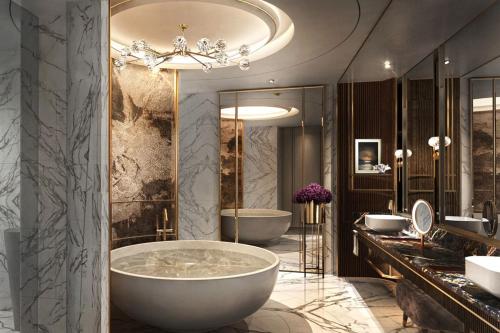 een badkamer met 2 wastafels en een groot bad bij Sheraton Kuching Hotel in Kuching