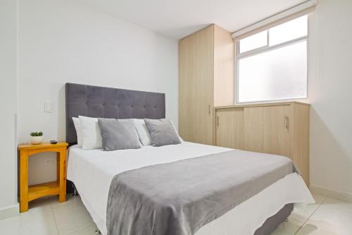 Un dormitorio con una cama grande y una ventana en Sabaneta Central Nómadas digitales Wi-Fi 401, en Sabaneta