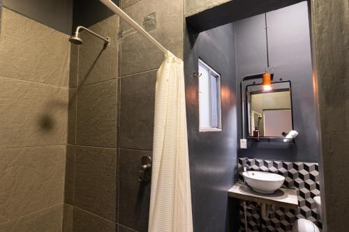 uma casa de banho com um chuveiro e uma cortina de chuveiro branca. em Selina Oaxaca em Oaxaca de Juárez