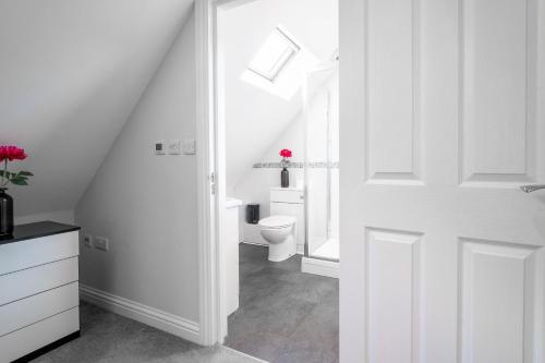 a bathroom with a toilet and a white door at Garland Penthouse in Redhill