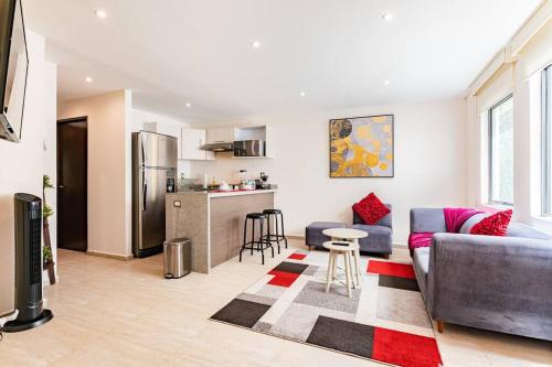 a living room with a couch and a kitchen at Moderno departamento en el corazón de la Roma in Mexico City