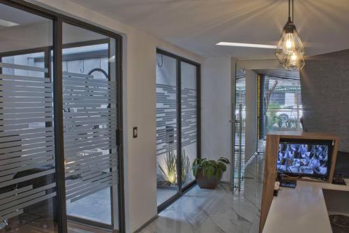 a living room with sliding glass doors and a tv at Moderno departamento en el corazón de la Roma in Mexico City