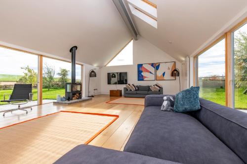 a living room with a couch and a fireplace at Architect Designed Lodge in Dunecht