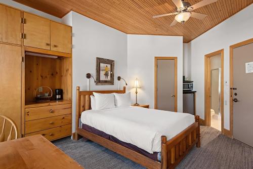 Un dormitorio con una gran cama blanca y una mesa en Independence Square 301, Great Hotel Room with Excellent Location & Rooftop Hot Tub en Aspen
