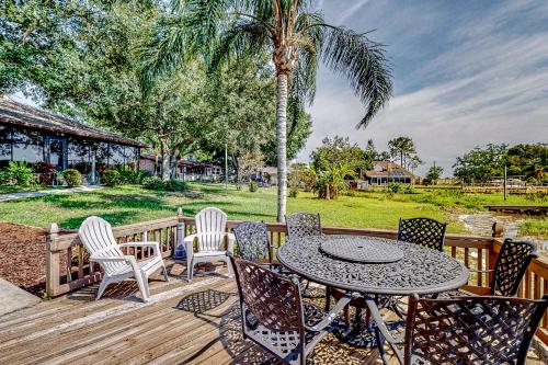 a patio with a table and chairs and a palm tree at Lakeside Sunset in Winter Haven