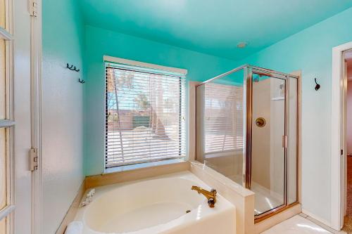 a bathroom with a tub and a glass shower at Desert Blooms in Avondale