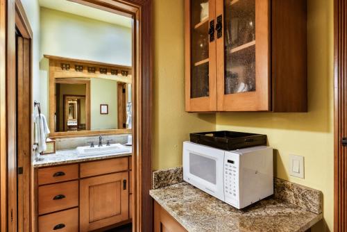 a kitchen with a sink and a microwave on a counter at Independence Square Unit 309, Downtown Hotel Room with A/C in Aspen, Wet Bar & More in Aspen