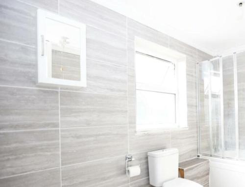 a bathroom with a toilet and a window at The Dunstable House in Houghton Regis