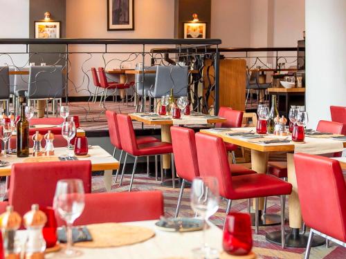 ein Restaurant mit Tischen, Stühlen und Weingläsern in der Unterkunft Novotel Glasgow Centre in Glasgow