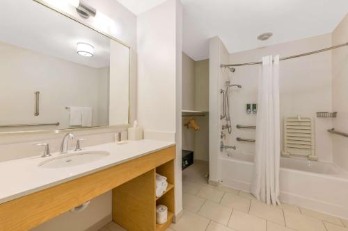 ein Badezimmer mit einem Waschbecken, einer Badewanne und einer Dusche in der Unterkunft Sonesta ES Suites Charlotte Arrowood in Charlotte