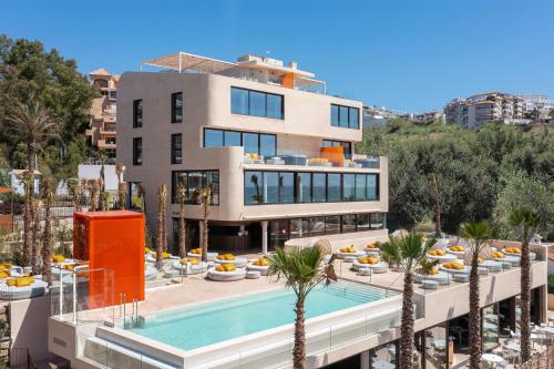 a building with a swimming pool and a resort at Higuerón Hotel Curio Collection by Hilton in Fuengirola