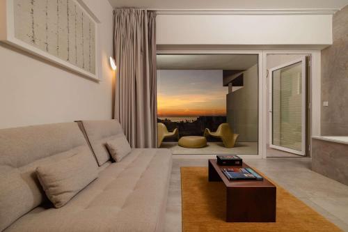 a living room with a couch and a large window at Higuerón Hotel Curio Collection by Hilton in Fuengirola