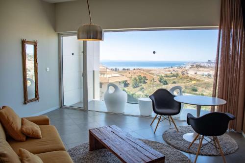 a living room with a couch and chairs and a large window at Higuerón Hotel Curio Collection by Hilton in Fuengirola