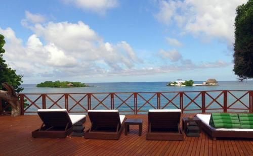 a deck with chairs and a view of the ocean at Isla Única- Islas del Rosario in Isla Grande