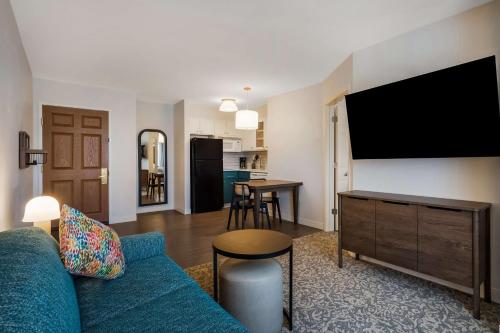 a living room with a blue couch and a flat screen tv at Sonesta ES Suites Denver South Park Meadows in Lone Tree