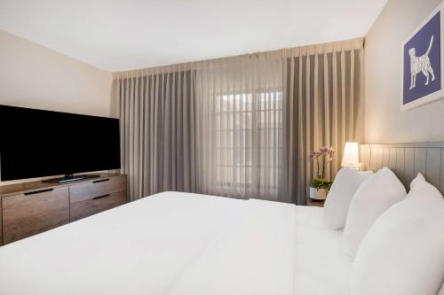 a bedroom with a large white bed and a television at Sonesta ES Suites Denver South Park Meadows in Lone Tree