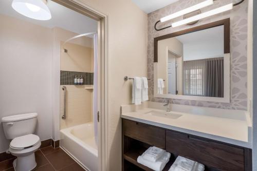 a bathroom with a sink and a toilet and a mirror at Sonesta ES Suites Denver South Park Meadows in Lone Tree