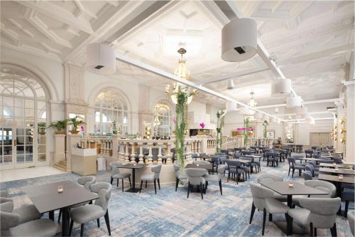 ブライトン＆ホーブにあるDoubleTree By Hilton Brighton Metropoleの建物内のテーブルと椅子のあるレストラン