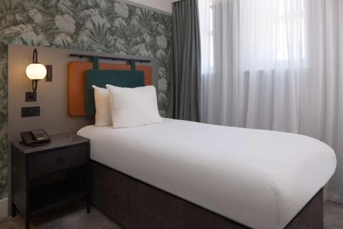 a bedroom with a large white bed and a window at DoubleTree By Hilton Brighton Metropole in Brighton & Hove