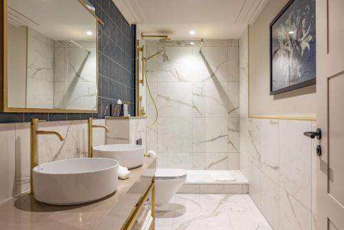 a bathroom with a tub and a sink and a toilet at DoubleTree By Hilton Brighton Metropole in Brighton & Hove