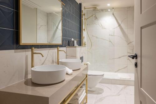 a bathroom with two sinks and a toilet and a tub at DoubleTree By Hilton Brighton Metropole in Brighton & Hove