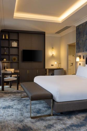 a hotel room with a large bed and a television at DoubleTree By Hilton Brighton Metropole in Brighton & Hove