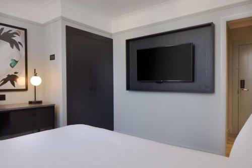 a bedroom with a flat screen tv on a wall at DoubleTree By Hilton Brighton Metropole in Brighton & Hove