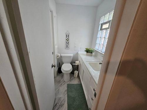 uma casa de banho com um WC, um lavatório e uma janela em 3bedroom Home@South Euclid em Cleveland